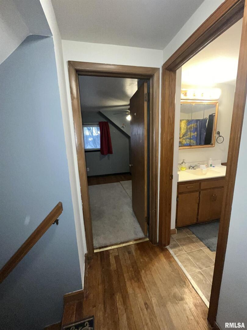 917 South 8th Street Clinton, IA 52732 - Photo 6 of 15 a view of a hallway and a livingroom with wooden floor and a bathroom