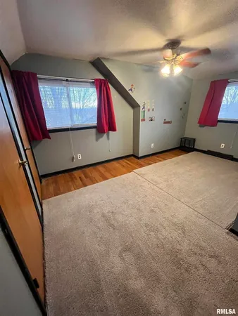 a view of an empty room with window and cabinet