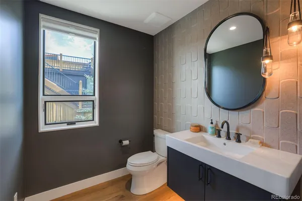 a bathroom with a toilet sink vanity granite and a mirror