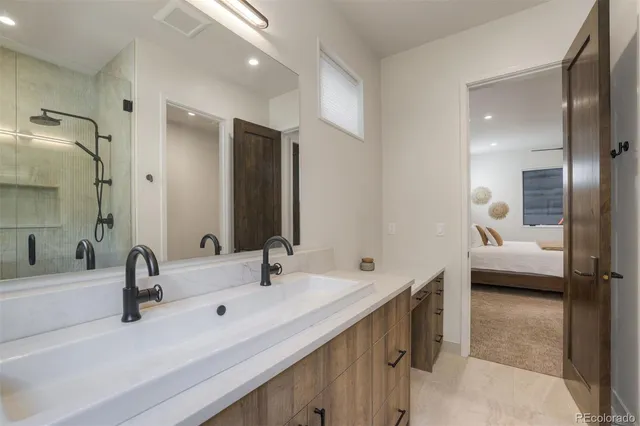 a en suite bathroom with a double vanity sink and a large mirror