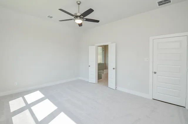 an empty room with a window and a fan