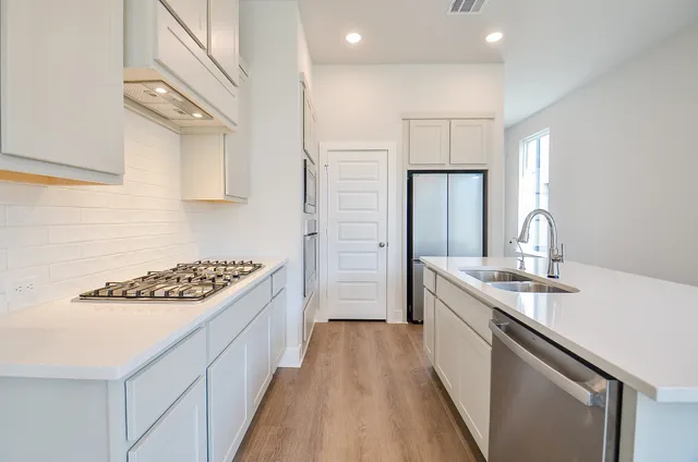 a kitchen with stainless steel appliances granite countertop a sink stove and refrigerator