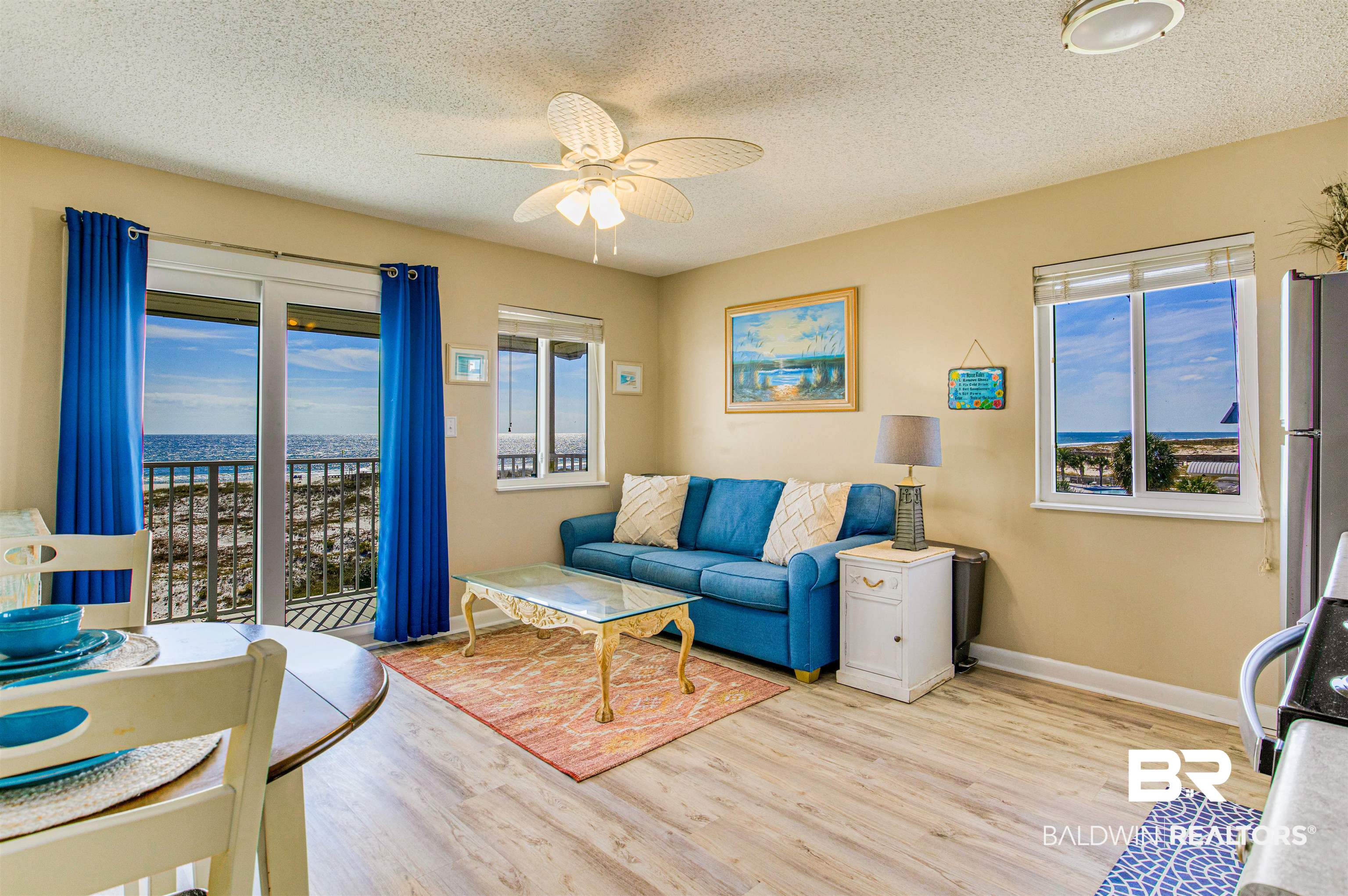400 Plantation Road, Unit 1303 Gulf Shores, AL 36542 - Photo 4 of 24 Combined living/dining room featuring Gulf front water view, ceiling fan, vinyl flooring & new doors/windows