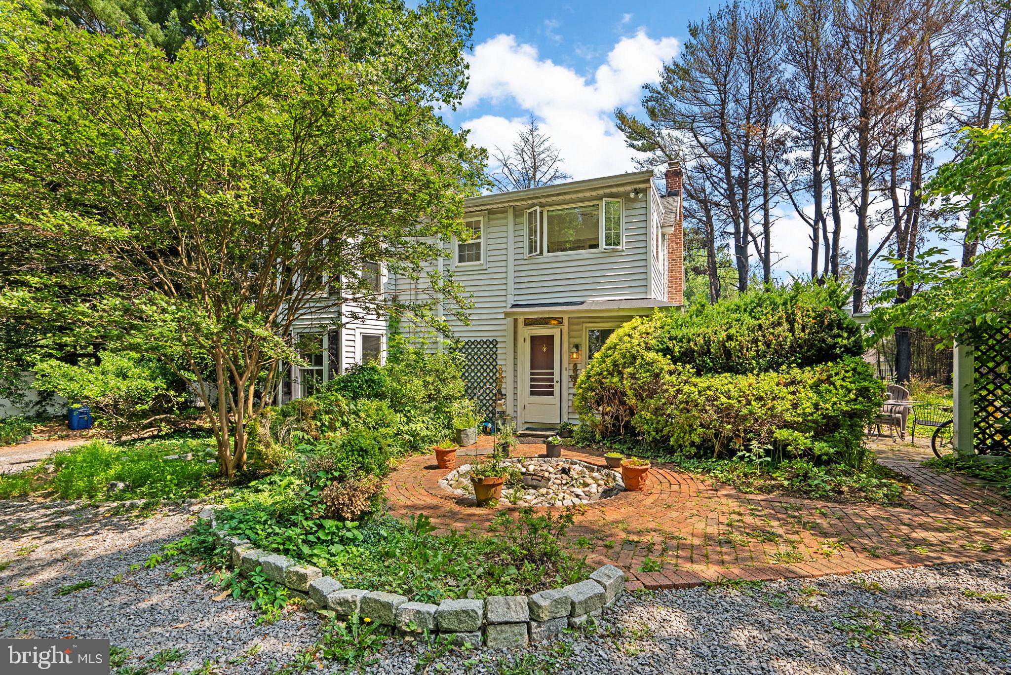 13321 Travilah Road Potomac, MD 20854 - Photo 3 of 43 a view of a backyard with plants and large trees