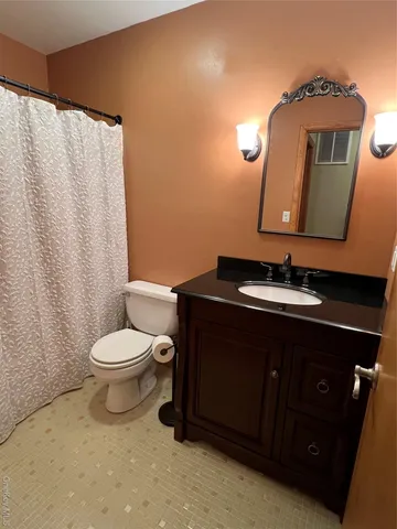 a bathroom with a sink vanity mirror and toilet