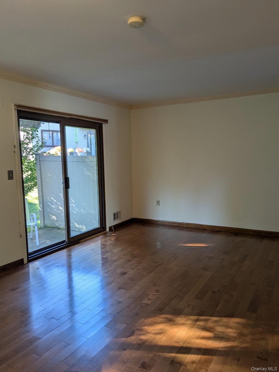 10 Squires Gate, Unit H Poughkeepsie, NY 12603 - Photo 2 of 24 a view of an empty room with wooden floor and a window