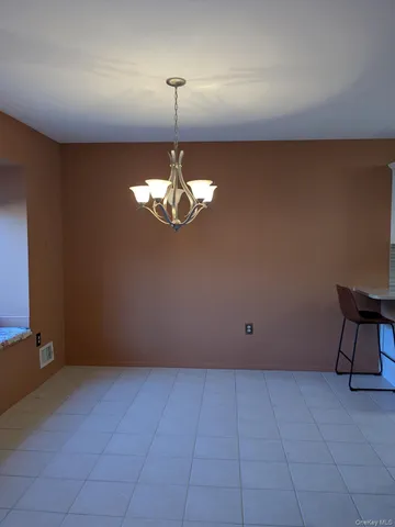a view of an empty room with a chandelier fan