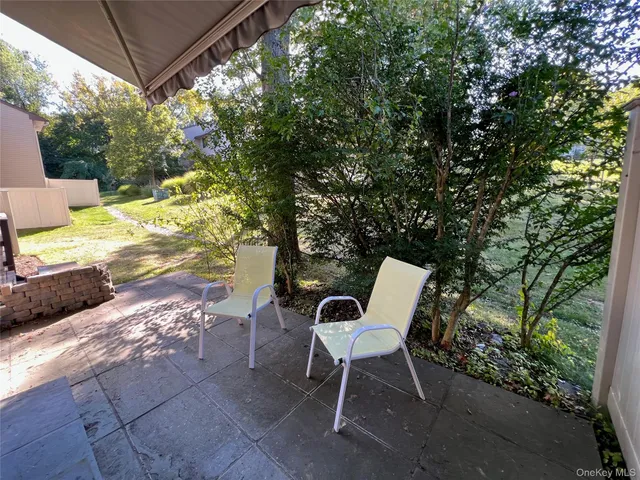a view of a patio with a table and chairs and potted plants