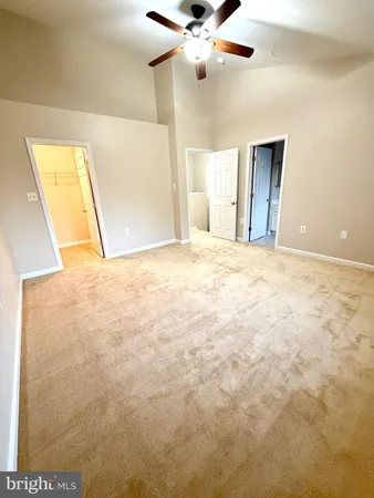 a view of an empty room with a chandelier fan