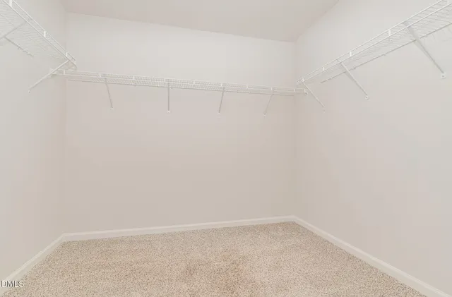 a view of a small space with wooden floor and mirror