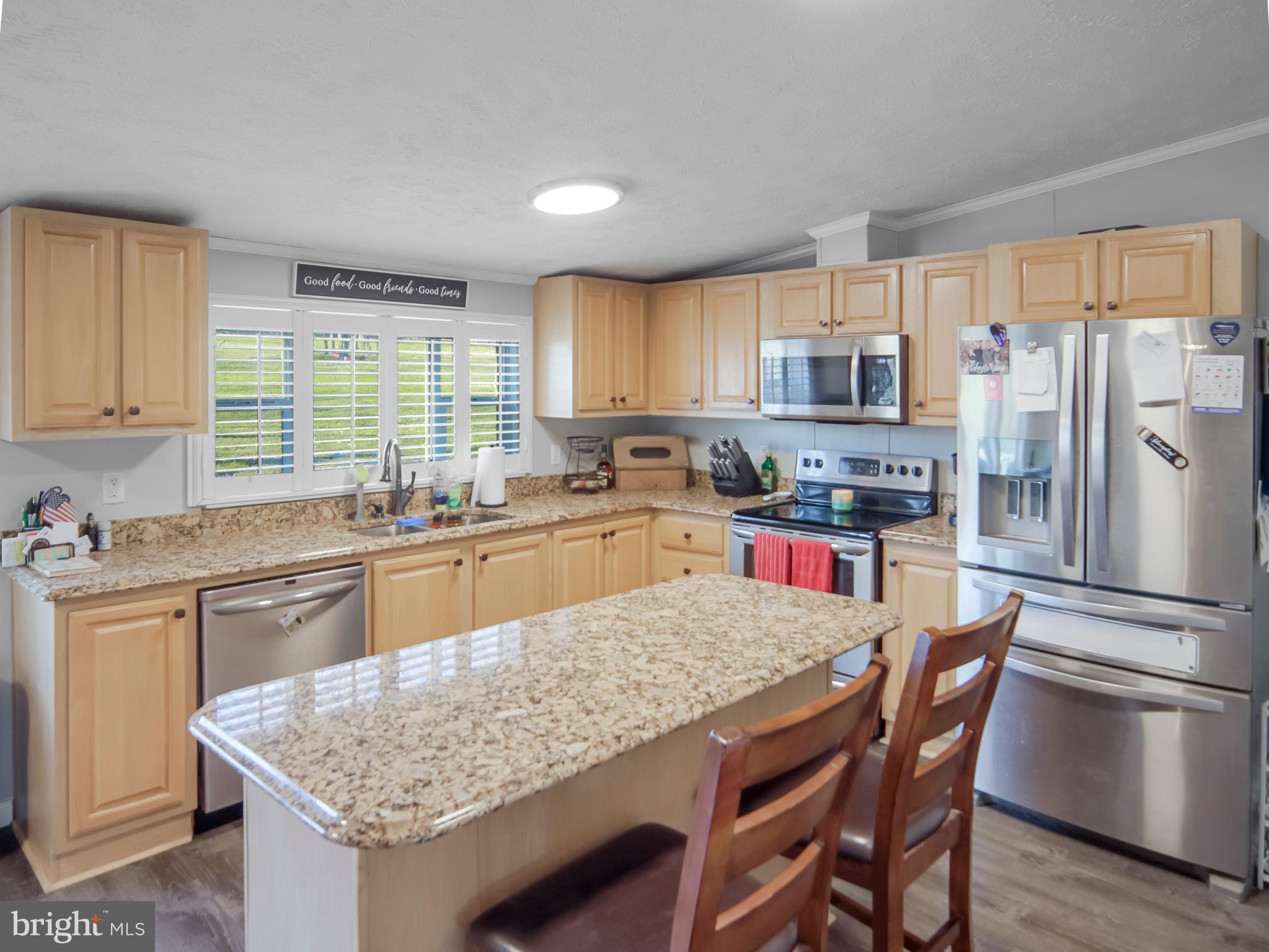 108 Rebel Drive Falling Waters, WV 25419 - Photo 22 of 27 a kitchen with stainless steel appliances granite countertop a table chairs sink refrigerator and cabinets
