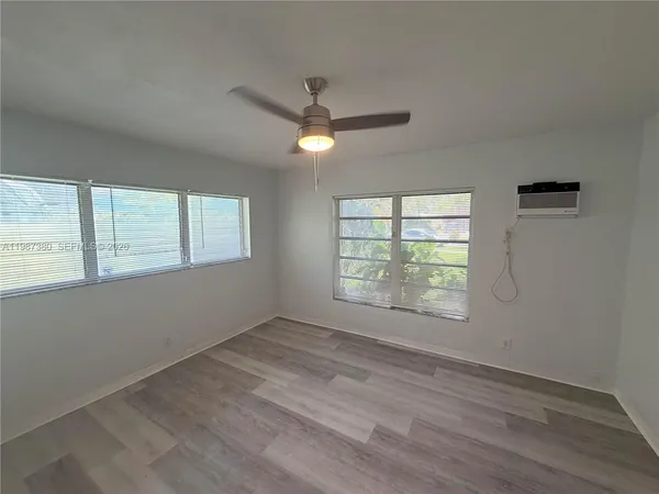a living room with hardwood floor and a ceiling fan