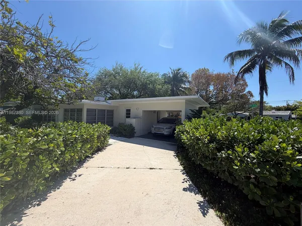 a front view of a house with a yard and potted plants