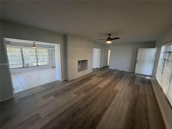 an empty room with wooden floor and fireplace