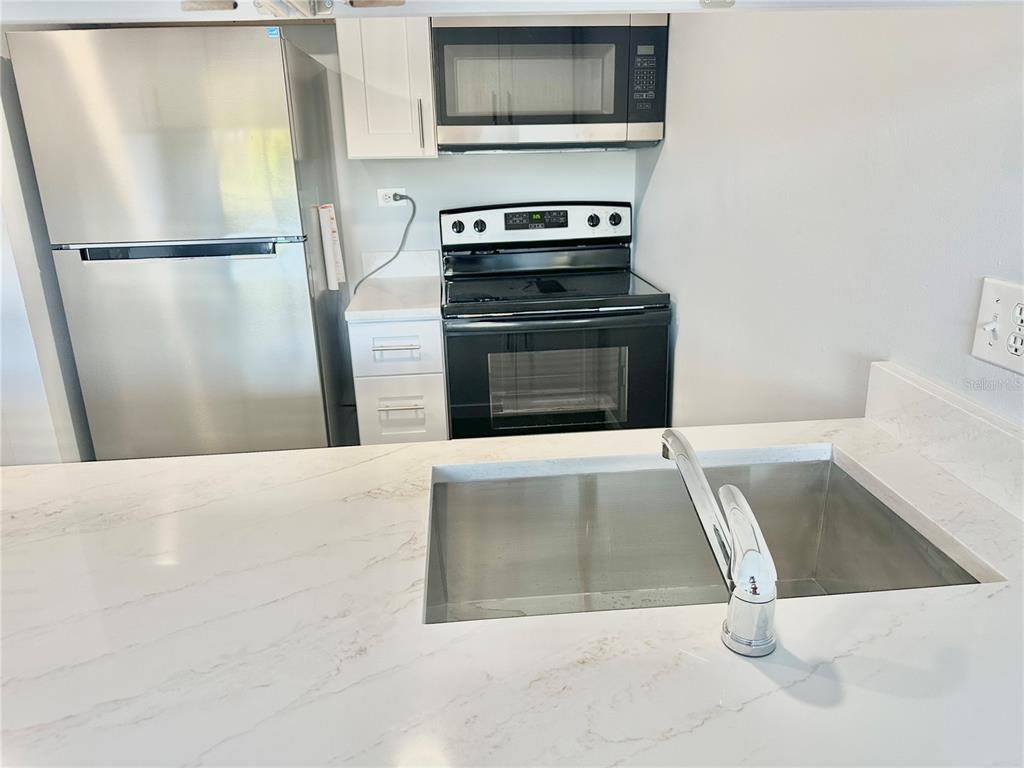 3760 Inverrary Drive, Unit 2M Lauderhill, FL 33319 - Photo 7 of 20 a kitchen with a refrigerator and a stove