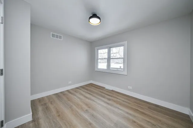 an empty room with windows and mirror