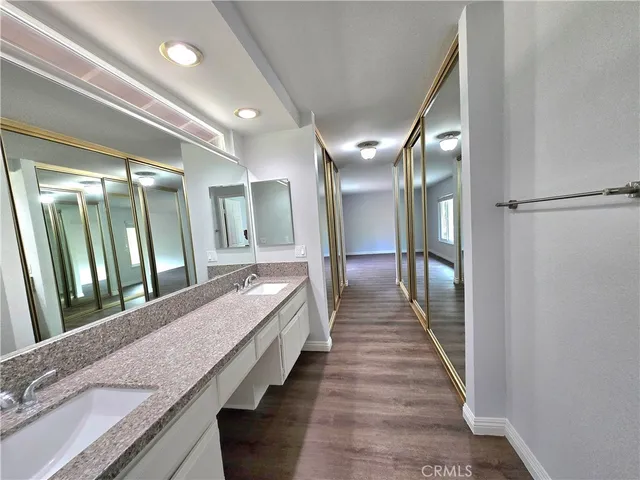 a bathroom with a granite countertop double vanity and a large mirror