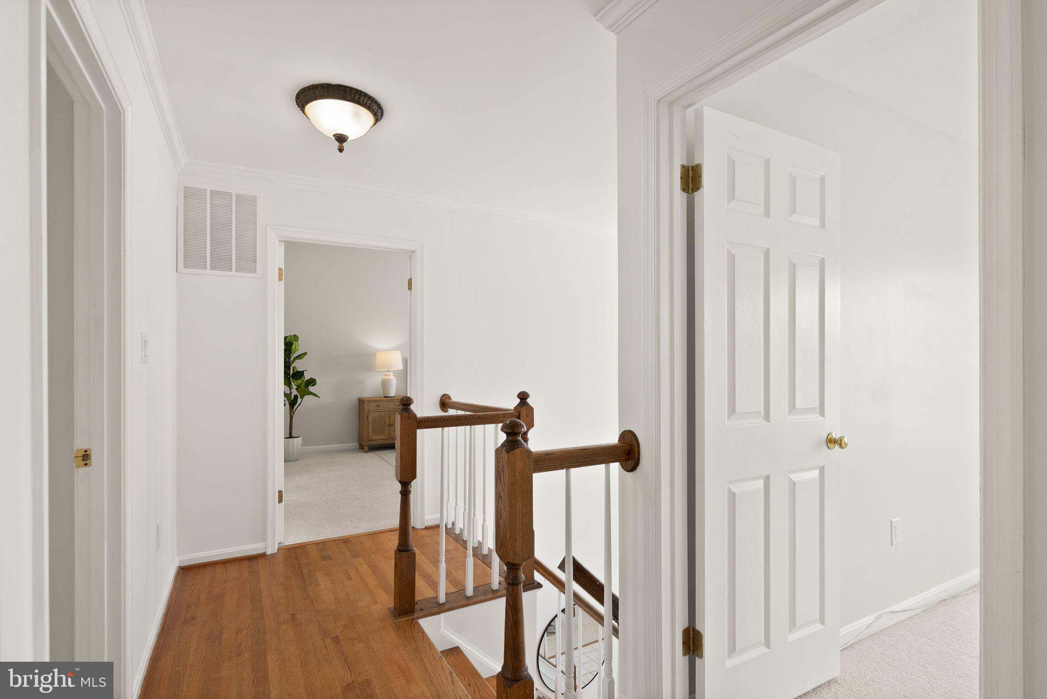 8144 Tall Timber Drive Gainesville, VA 20155 - Photo 31 of 73 a view of a hallway with wooden floor and stairs