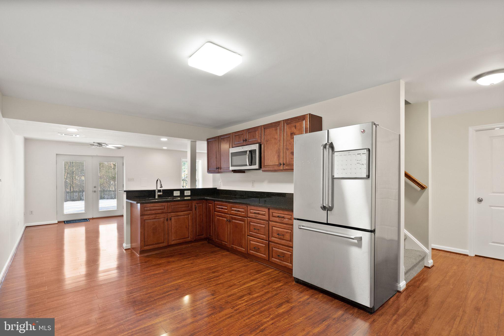 8144 Tall Timber Drive Gainesville, VA 20155 - Photo 49 of 73 a kitchen with granite countertop a refrigerator stove top oven and sink
