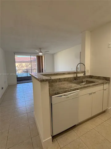 a kitchen with granite countertop a sink and cabinets