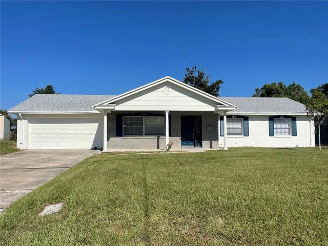 a front view of a house with a garden and yard