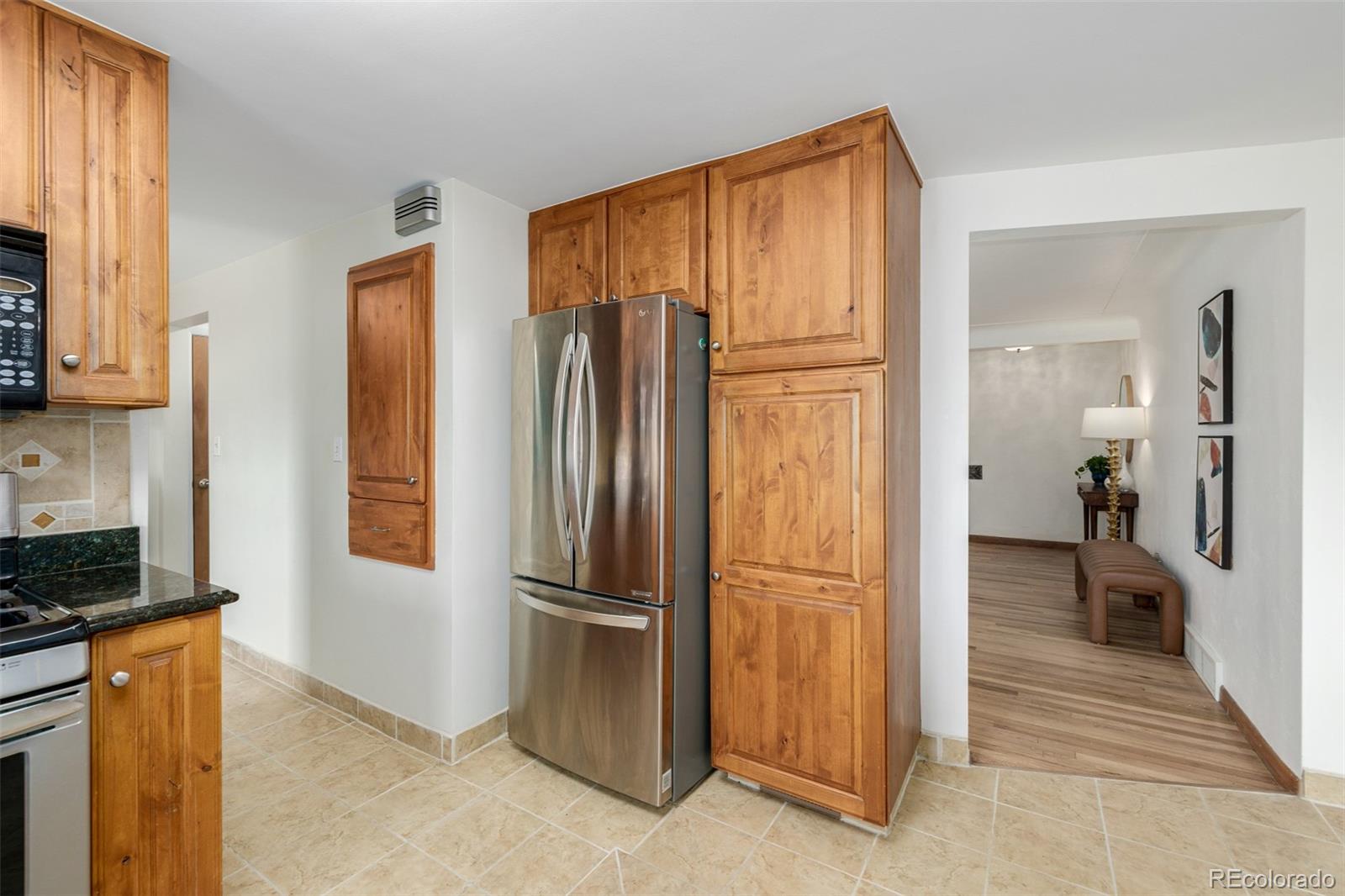 3880 Balsam Street Wheat Ridge, CO 80033 - Photo 19 of 40 a kitchen with stainless steel appliances granite countertop a refrigerator and a stove top oven