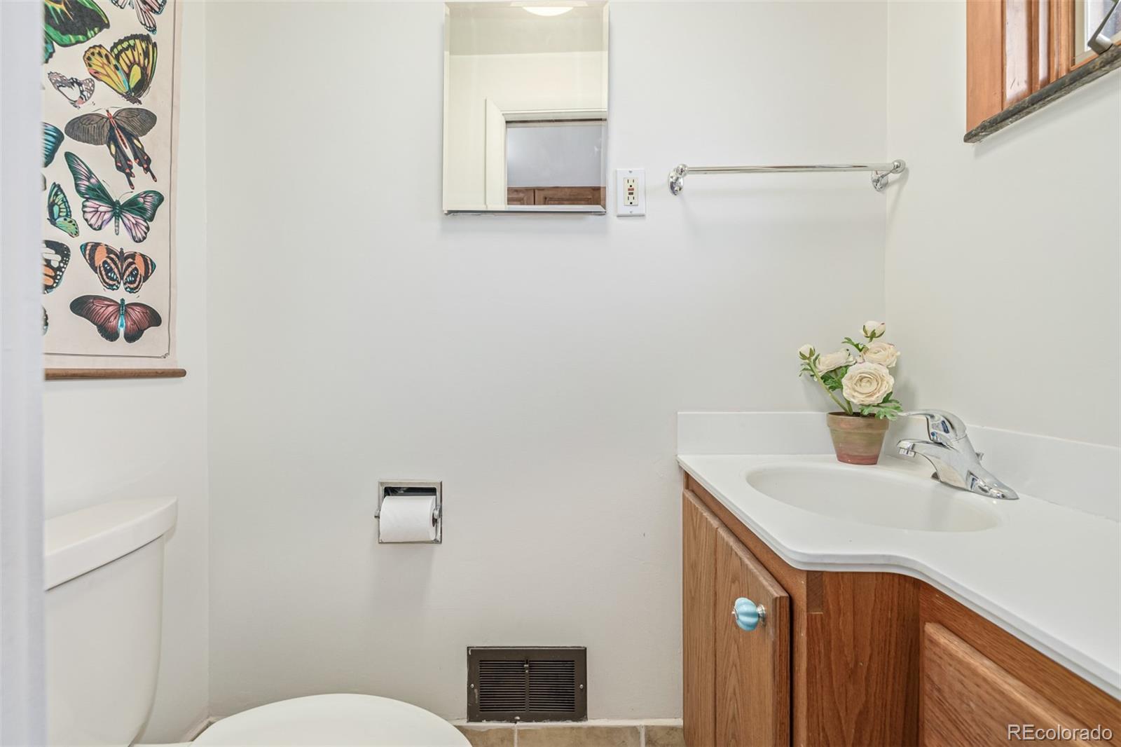 3880 Balsam Street Wheat Ridge, CO 80033 - Photo 25 of 40 a bathroom with a sink mirror vanity and toilet