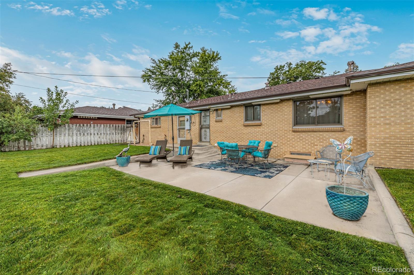 3880 Balsam Street Wheat Ridge, CO 80033 - Photo 35 of 40 a view of a backyard with table and chairs potted plants and wooden fence