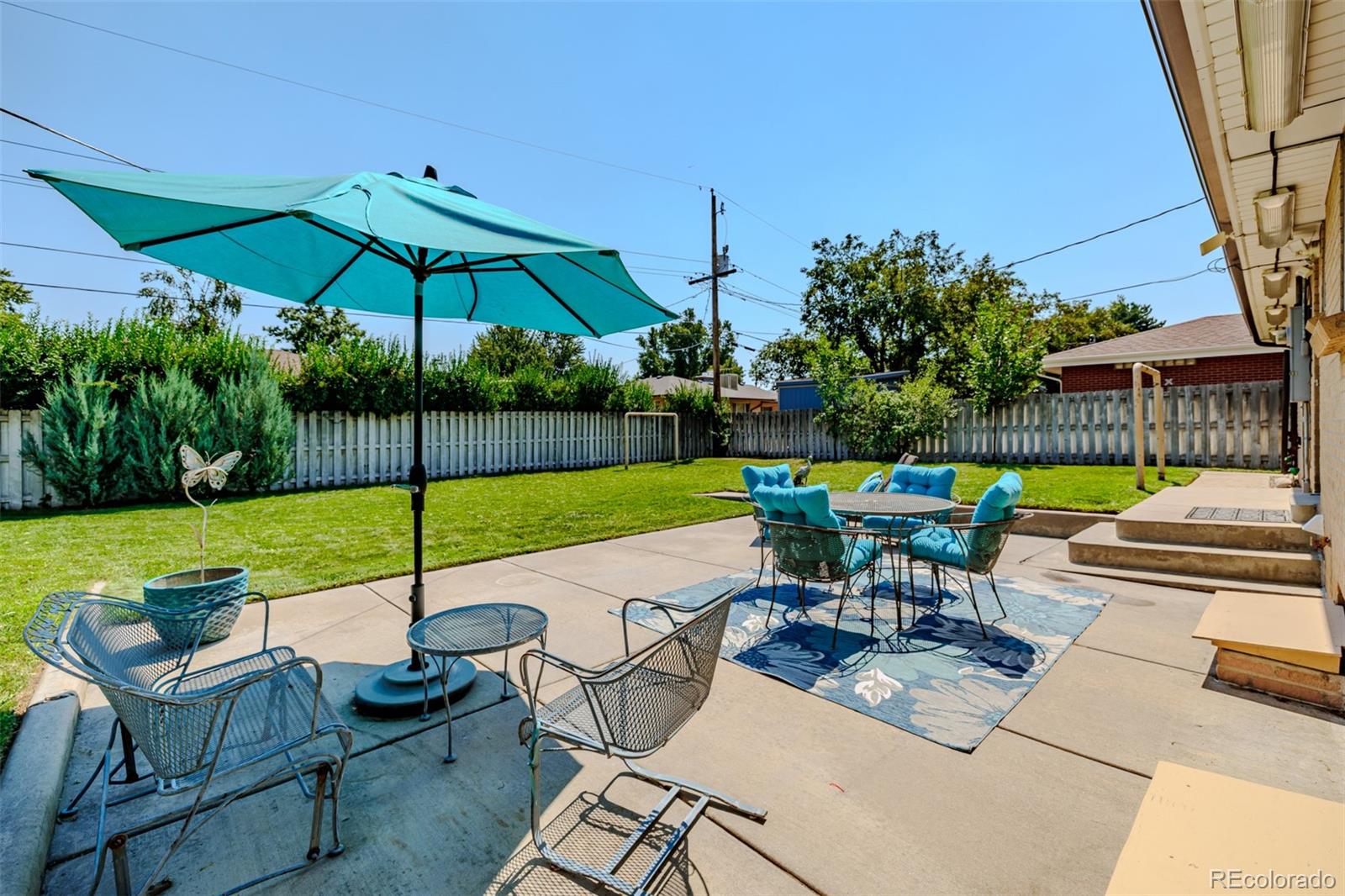 3880 Balsam Street Wheat Ridge, CO 80033 - Photo 39 of 40 a view of a table and chairs under an umbrella in backyard