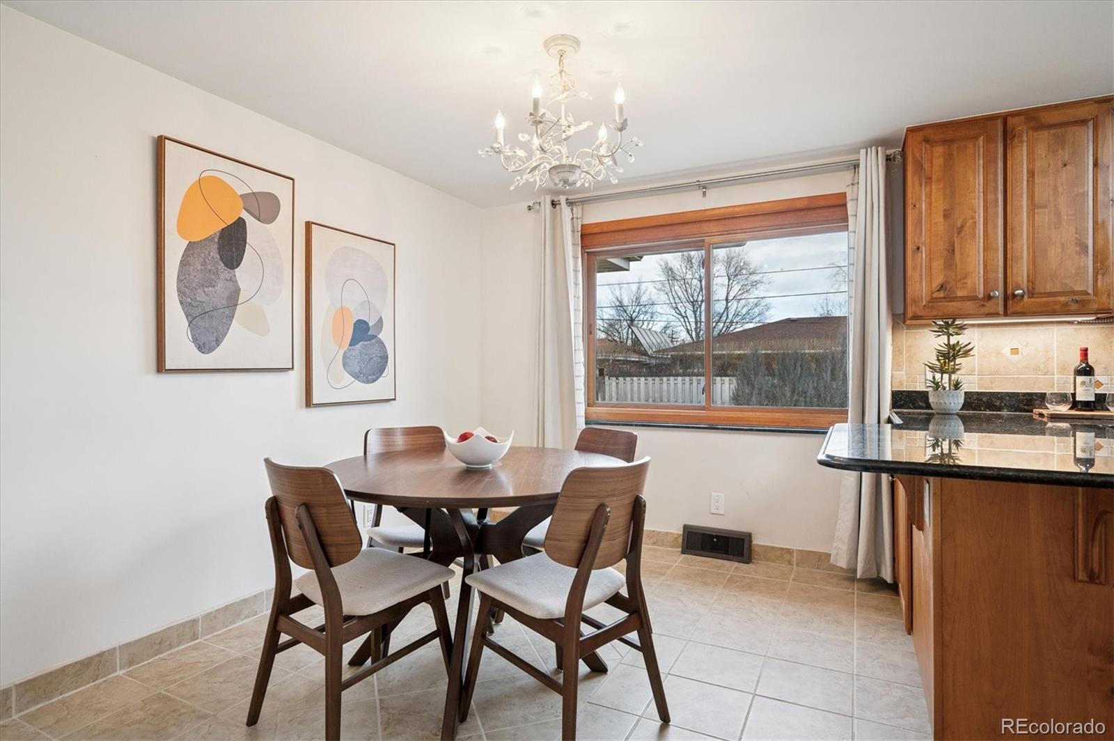 3880 Balsam Street Wheat Ridge, CO 80033 - Photo 6 of 40 a view of a dining room with furniture a chandelier and window