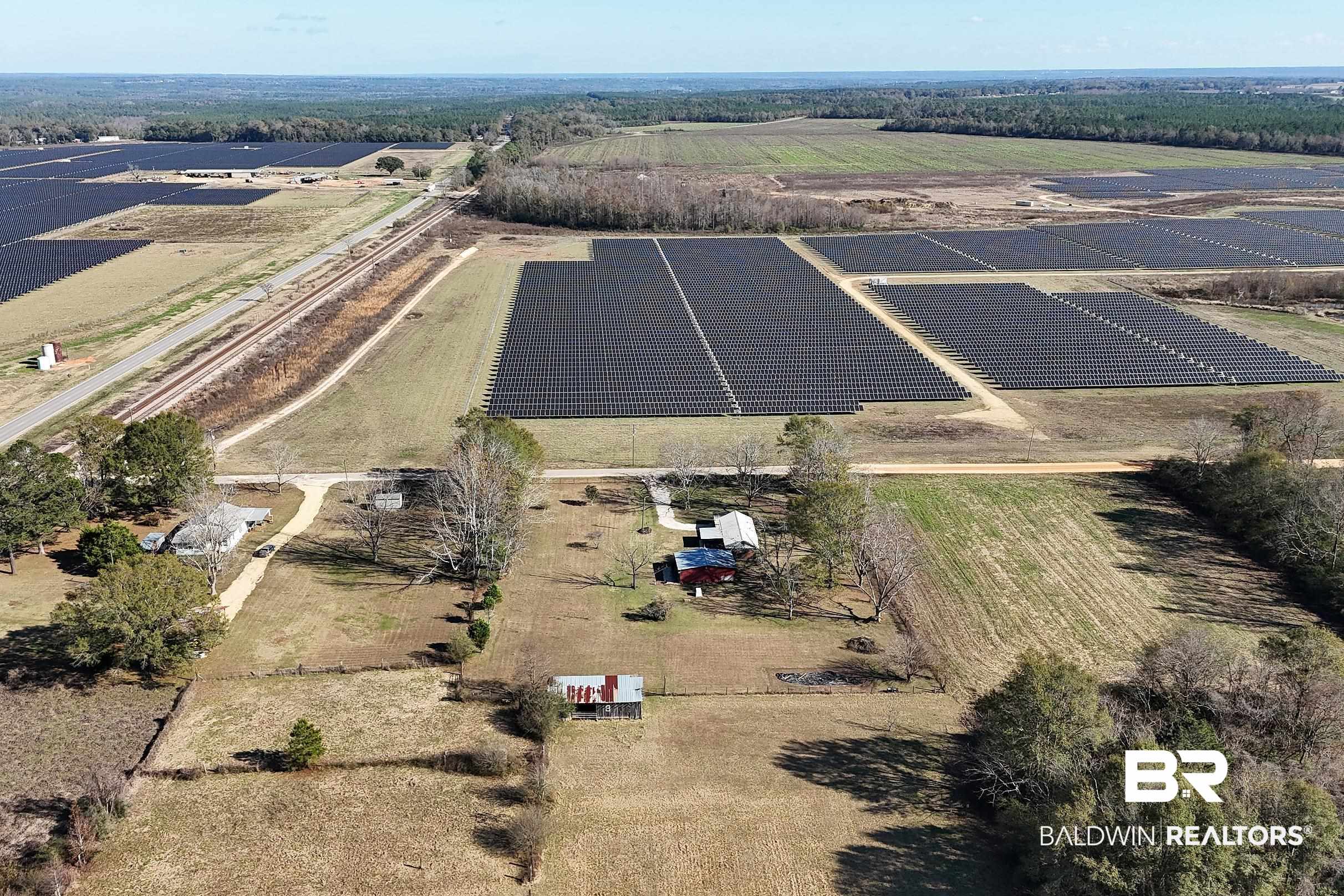 110 Sam Jones Road Atmore, AL 36502 - Photo 34 of 47 Aerial view of property and surrounding area with rural landscape and rows of crops