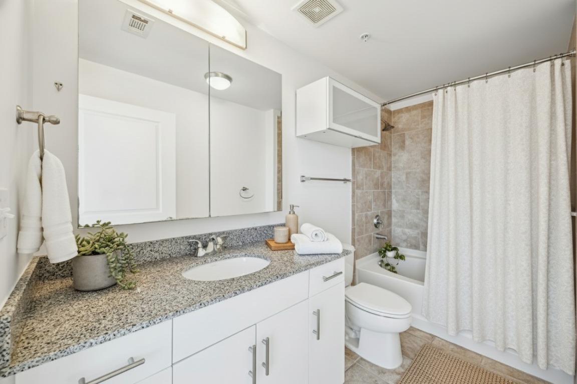 360 Nueces Street, Unit 4008 Austin, TX 78701 - Photo 3 of 40 a bathroom with a granite countertop sink and a mirror