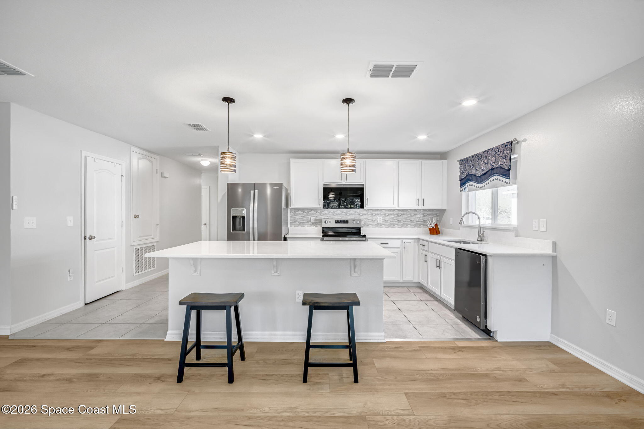 1219 Moscato Drive Titusville, FL 32780 - Photo 8 of 21 a kitchen with kitchen island a dining table chairs stainless steel appliances and cabinets