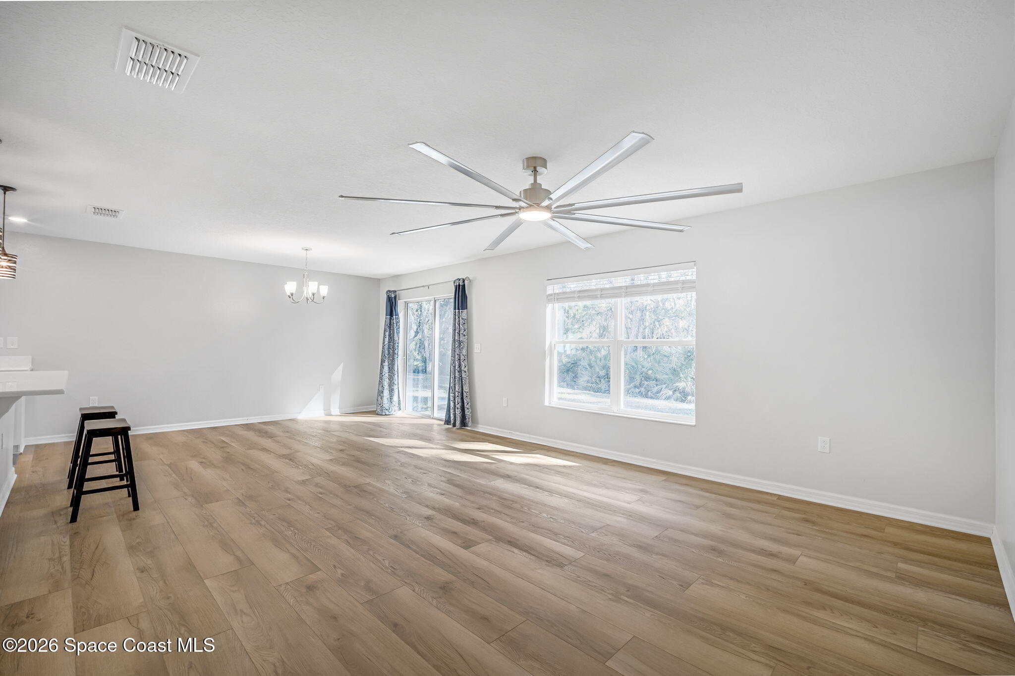 1219 Moscato Drive Titusville, FL 32780 - Photo 9 of 21 a view of an empty room with wooden floor and a window