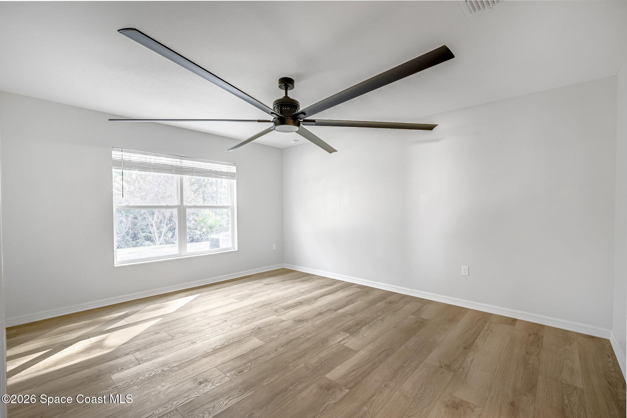 1219 Moscato Drive Titusville, FL 32780 - Photo 10 of 21 an empty room with wooden floor fan and windows