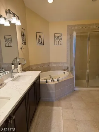 a bathroom with a granite countertop tub sink and mirror