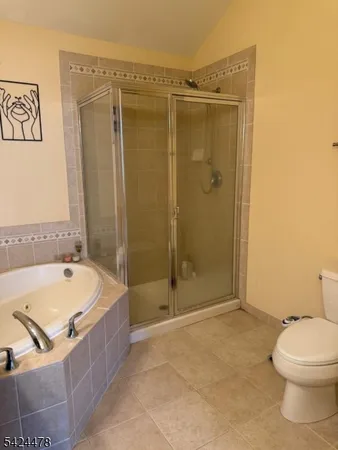 a bathroom with a granite countertop bathtub shower and toilet
