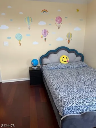 a bedroom with a bed and painting on the wall
