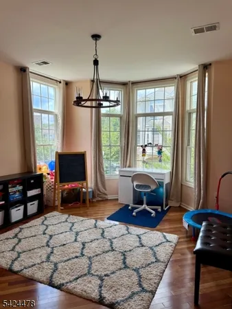 a living room with furniture a flat screen tv and a floor to ceiling window