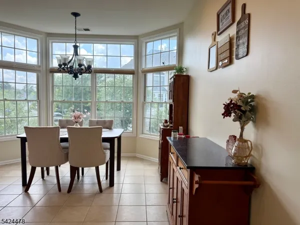 a dining room with furniture potted plants and wooden floor