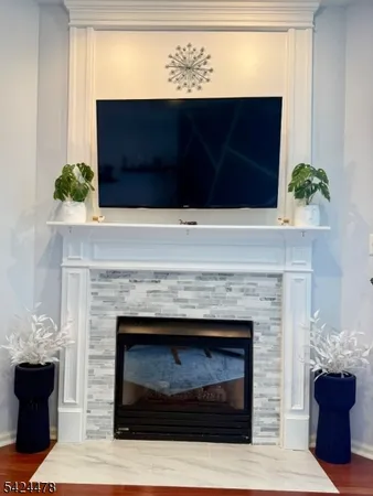 a living room with a fireplace and a potted plant
