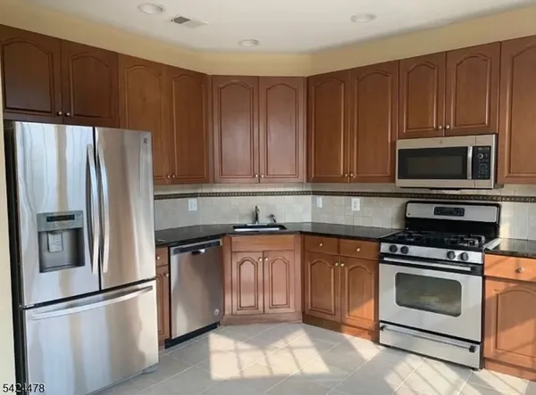 a kitchen with granite countertop wooden cabinets and stainless steel appliances