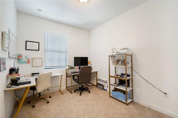 a view of a workspace with furniture and a window