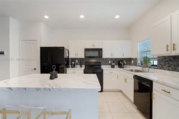 a kitchen with granite countertop a sink stainless steel appliances and cabinets