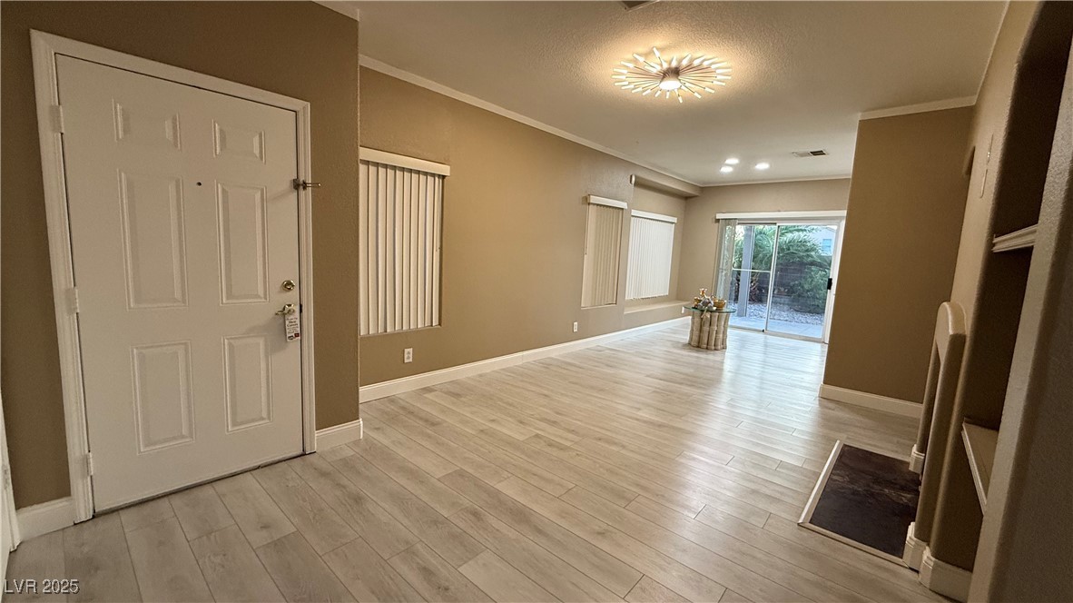 7062 Russell Ranch Avenue Las Vegas, NV 89113 - Photo 13 of 32 Foyer with baseboards, visible vents, light wood-type flooring, and ornamental molding