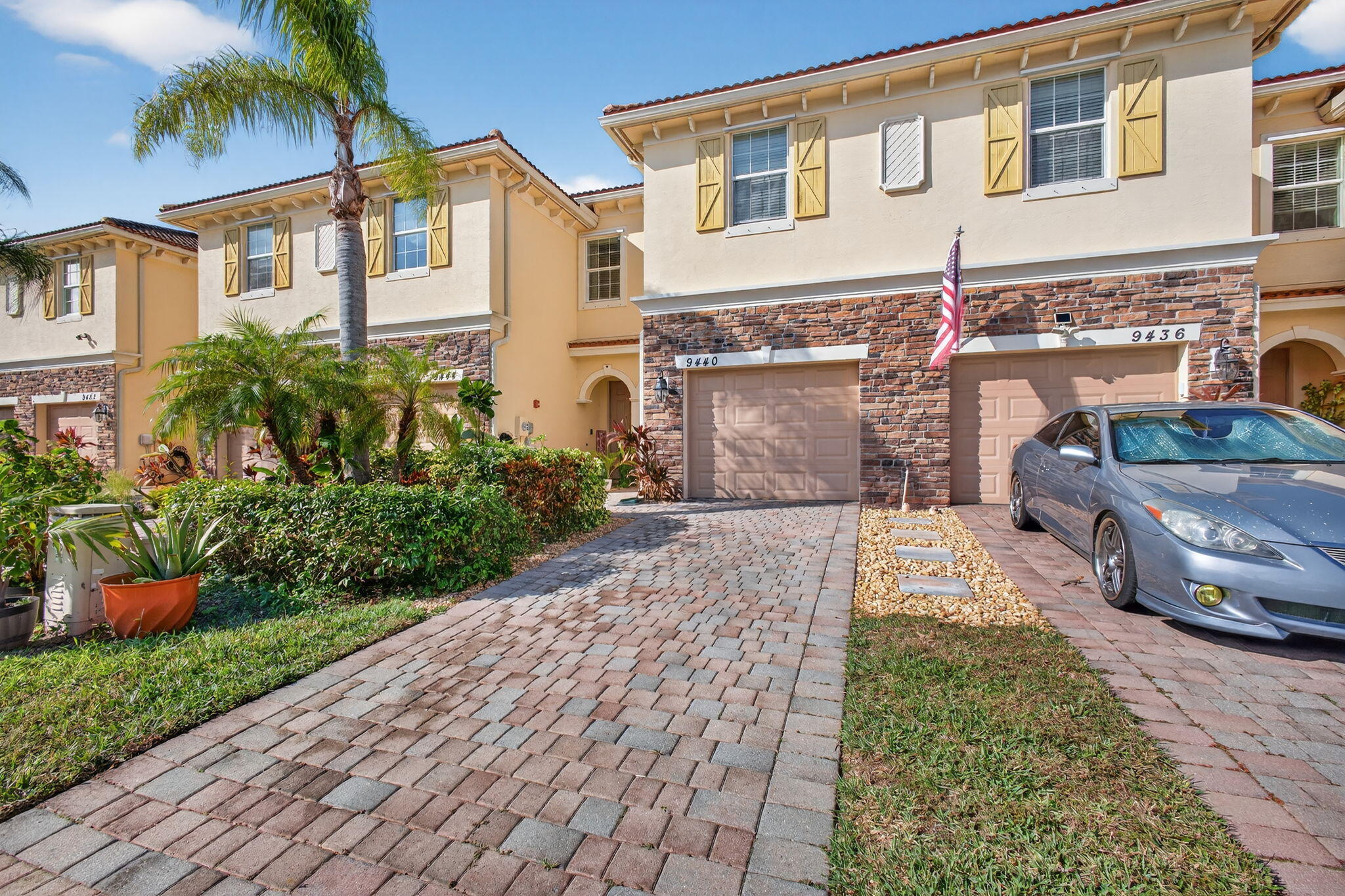 a front view of a house with a yard and potted plants