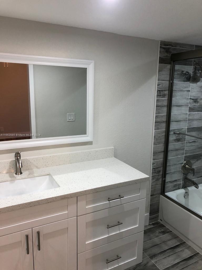 9273 Southwest 8th Street, Unit 310 Boca Raton, FL 33428 - Photo 11 of 21 a bathroom with a sink and a mirror