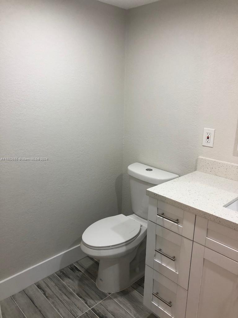 9273 Southwest 8th Street, Unit 310 Boca Raton, FL 33428 - Photo 3 of 21 a white toilet sitting next to a white cabinet