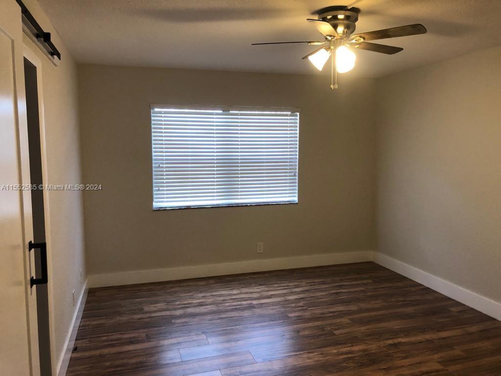 9273 Southwest 8th Street, Unit 310 Boca Raton, FL 33428 - Photo 5 of 21 wooden floor in an empty room with a window