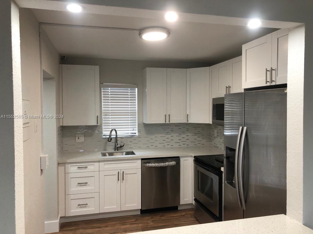 9273 Southwest 8th Street, Unit 310 Boca Raton, FL 33428 - Photo 8 of 21 a kitchen with stainless steel appliances granite countertop a sink stove and refrigerator